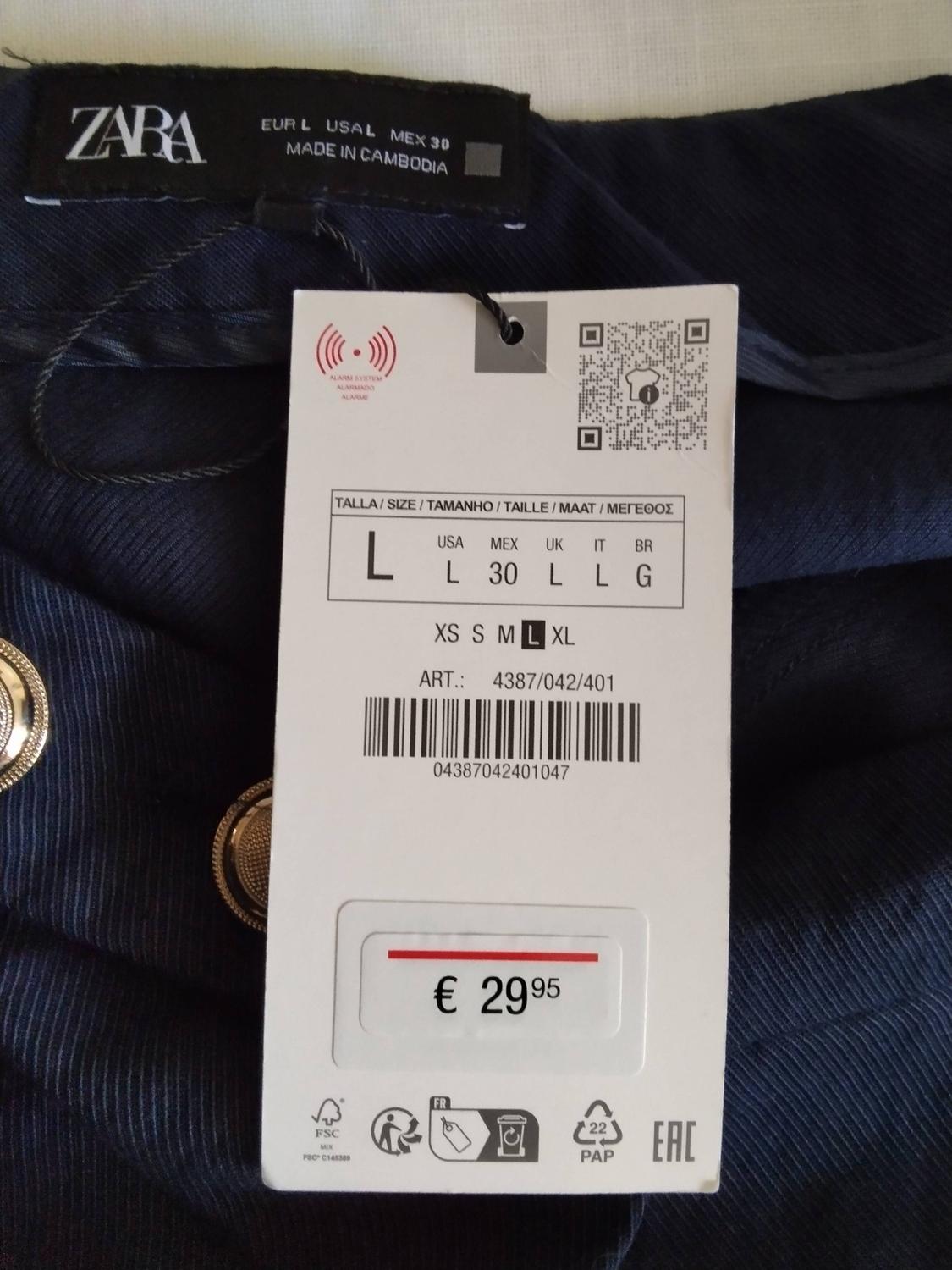 Blue garment with gold-coloured buttons. Labels with the text ZARA EUR L USA L MEX 30 MADE IN CAMBODIA, size L, ART.: 4387/042/401 and €29.95.