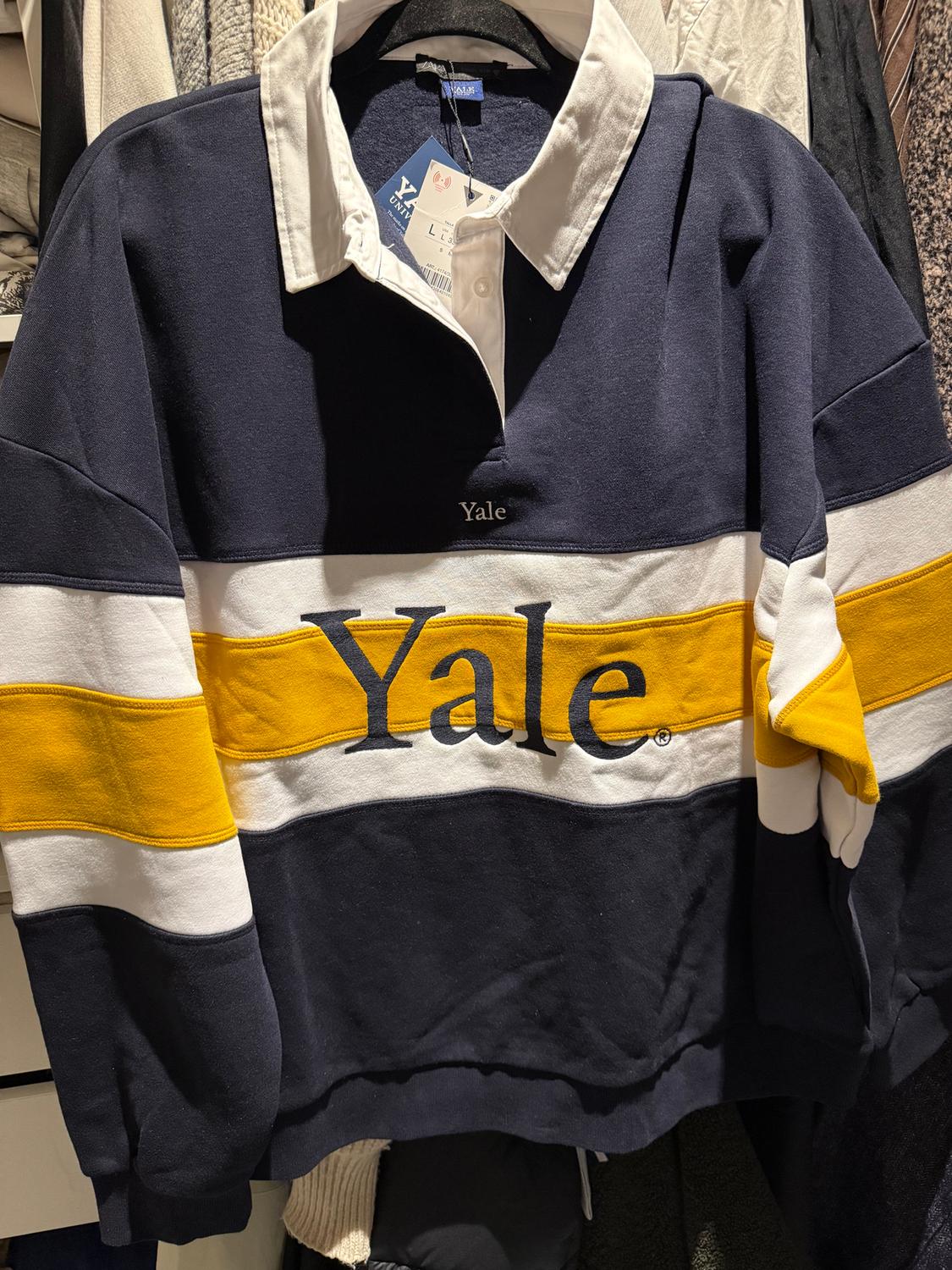 Navy blue sweatshirt with white collar and yellow and white stripes. "Yale" text on chest. Visible swing tag.