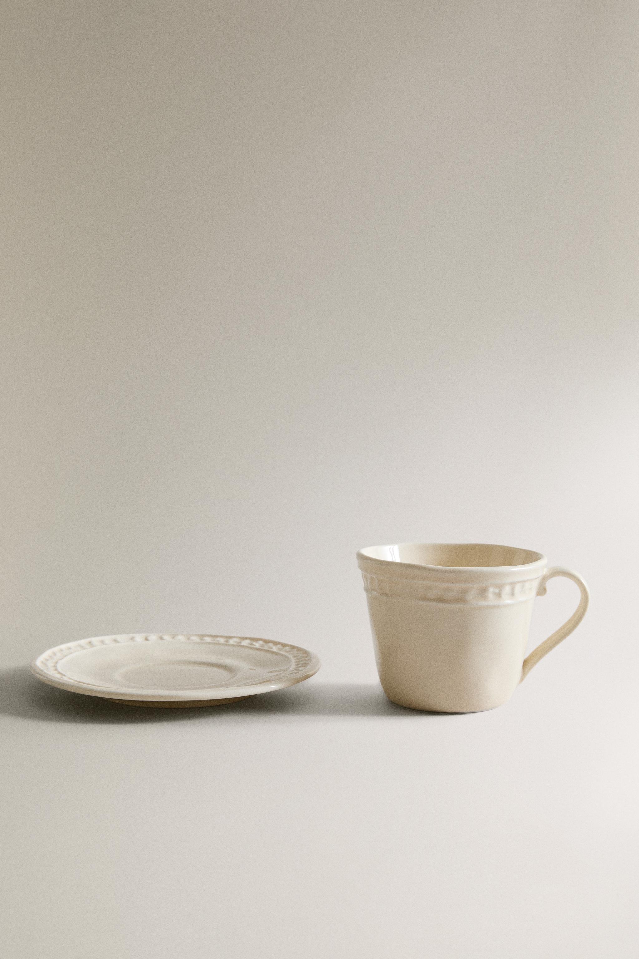 STONEWARE RAISED DESIGN COFFEE CUP AND SAUCER