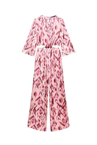 Front view of a pink patterned jumpsuit with a fitted waist and long sleeves.