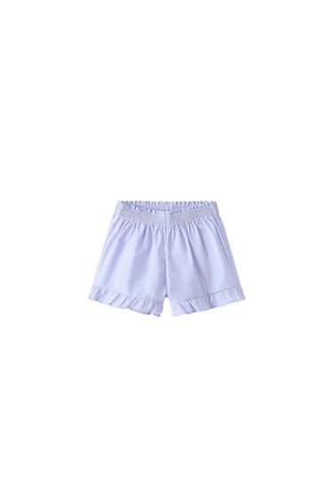 Light lilac shorts with a gathered elasticated waist and frill detail at the hem, on a white background.