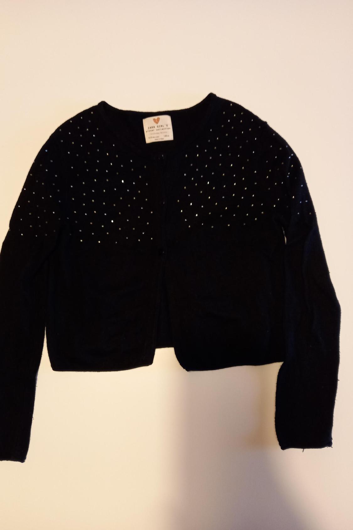Front view of a black cardigan with sparkly details on the top.