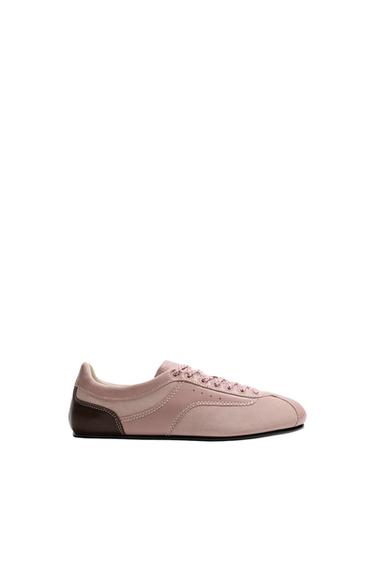 Side view of pink sneaker with contrast stitching, brown back and colored lace-up closure. Flat sole.