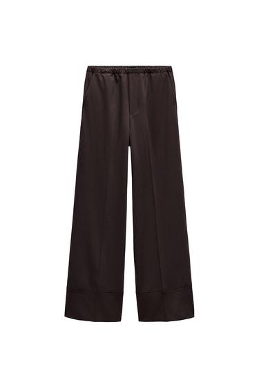 Front view of black trousers with elasticated waistband and side pockets.