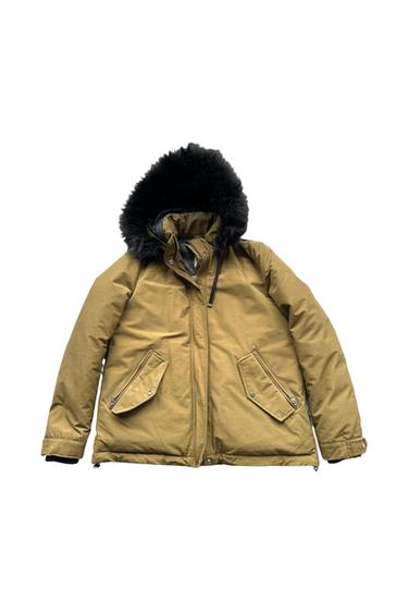 Brown jacket with a black faux fur hood, zip fastening, and flap pockets. White background.