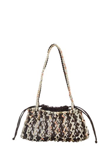 Multicoloured woven bag with braided handle and adjustable drawstring fastening.