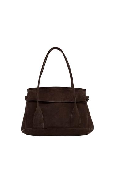 Dark brown handbag with long handles and minimalist design on a white background.