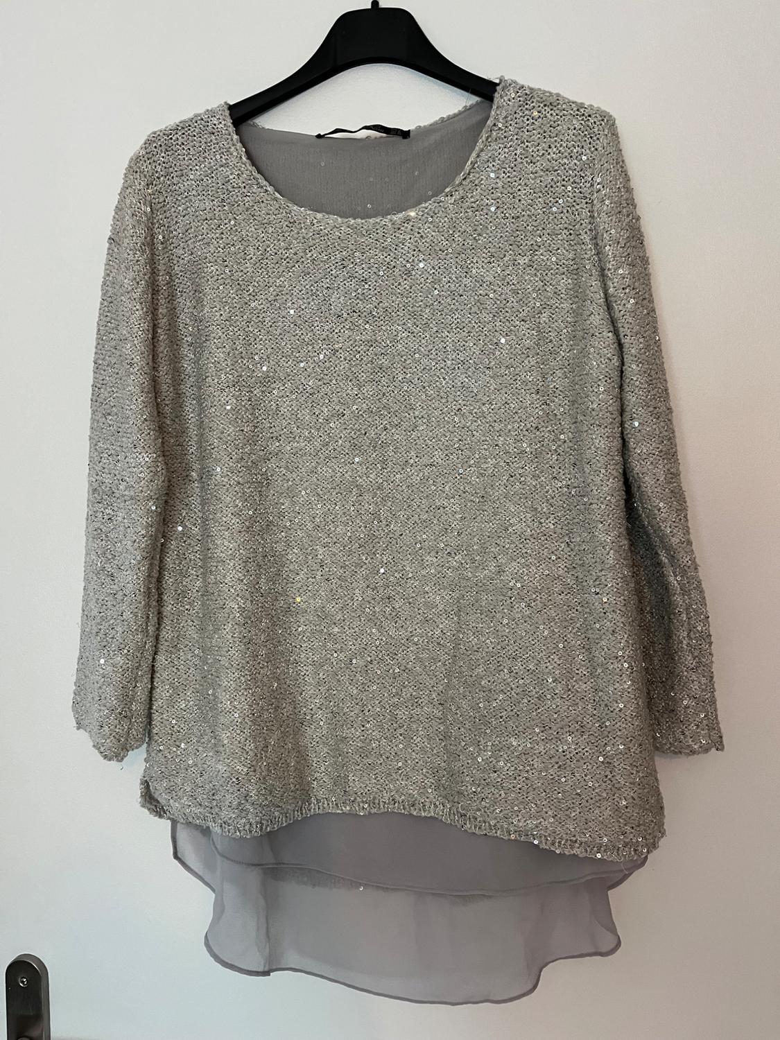 Front view of grey sequinned blouse with asymmetric chiffon hem.