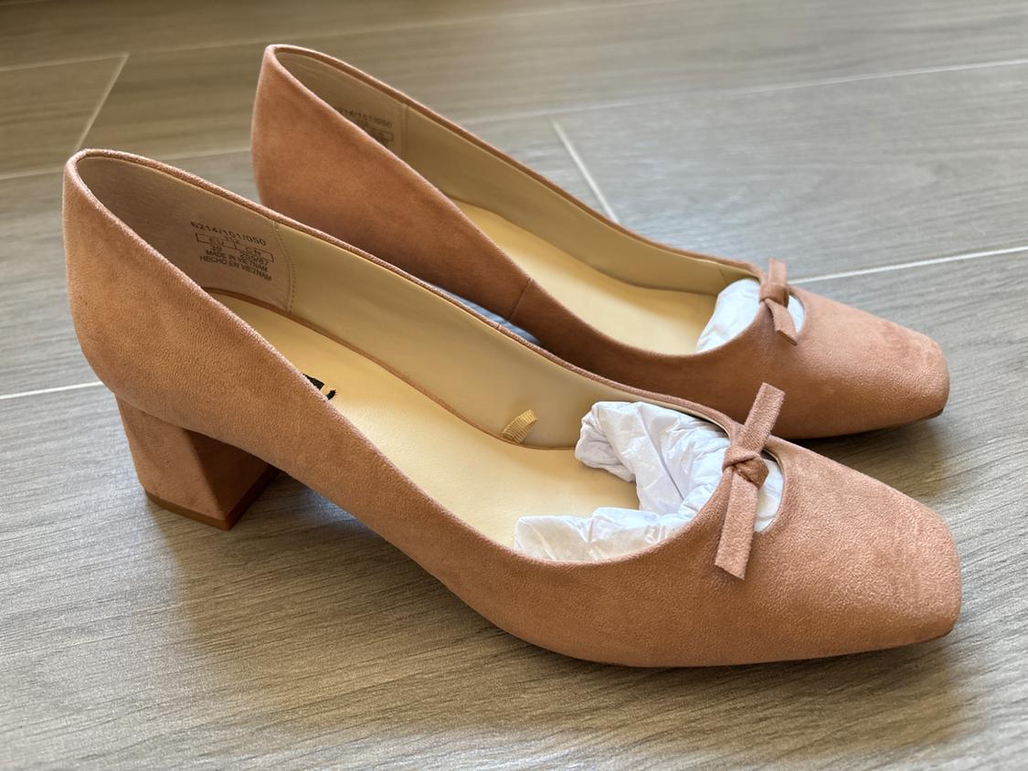 Beige low-heeled shoes with a bow on top.