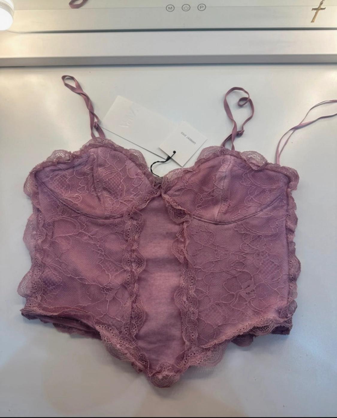 Mauve lace camisole with delicate straps on a white background. Labels featuring the text ZARA and GARMENT DYED.
