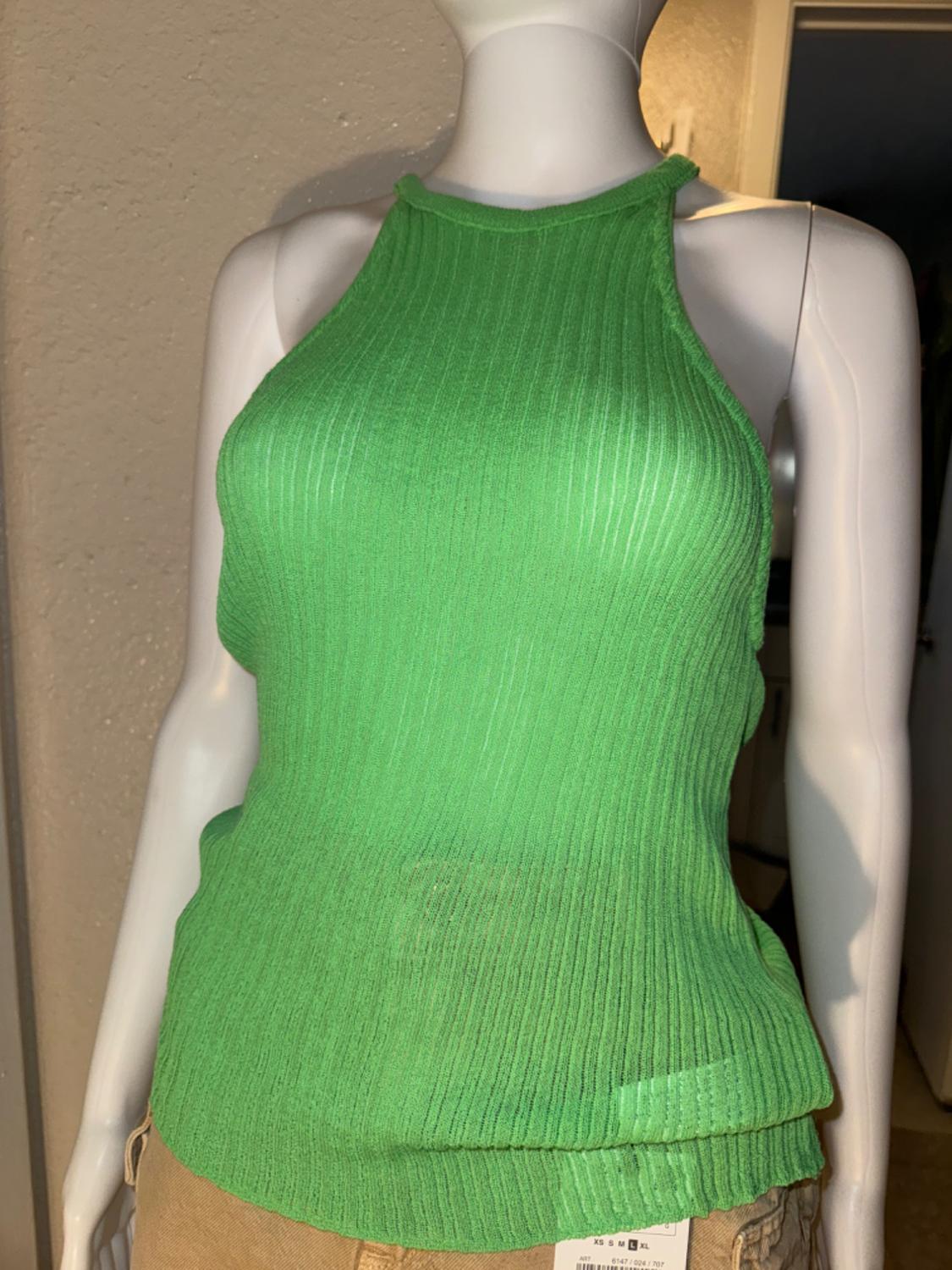 Mid shot of a green ribbed top with a high crew neck.