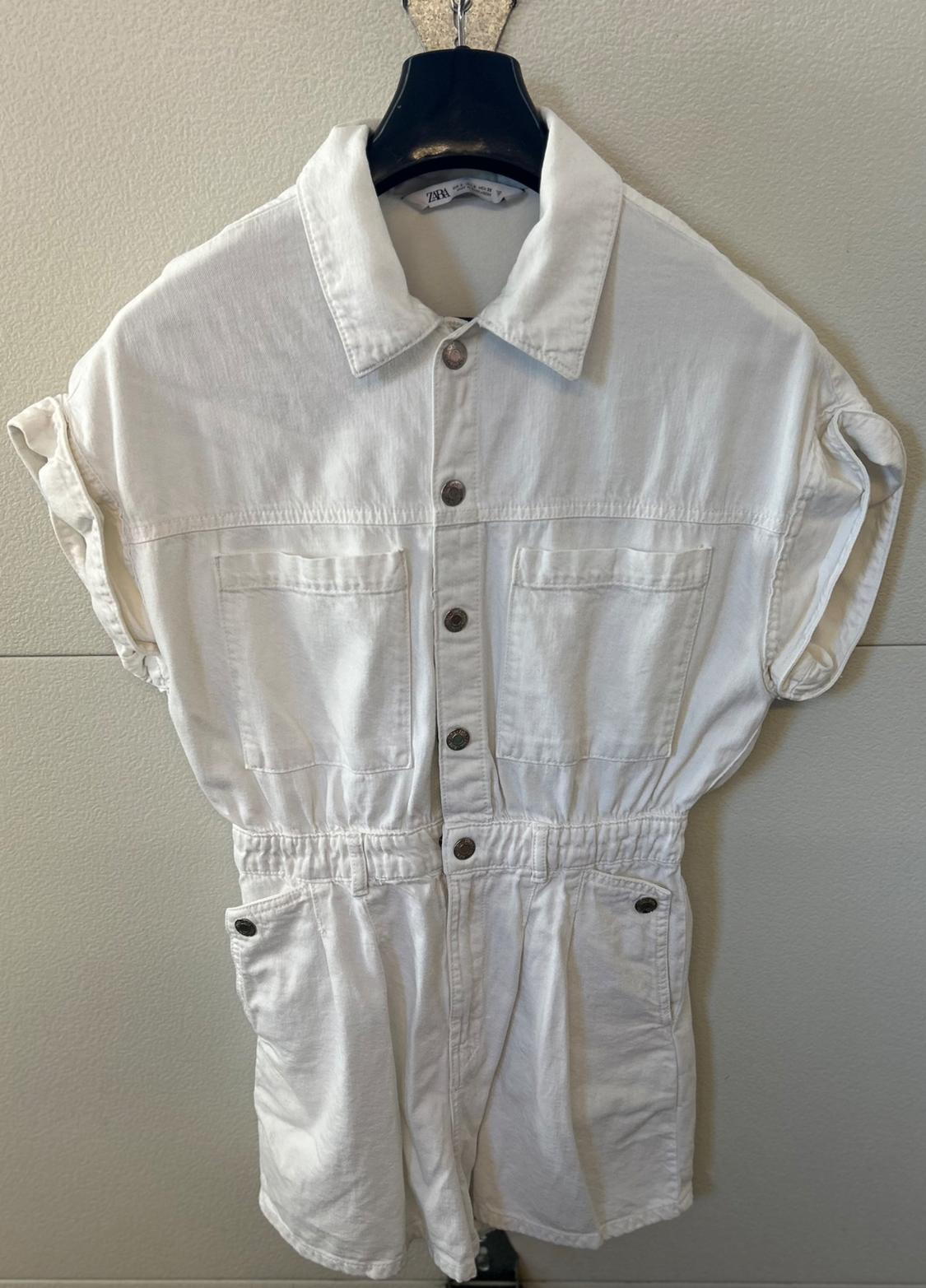 Front view of a white jumpsuit with a collar, front pockets, and buttons.