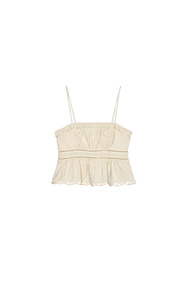 Front view of a beige camisole top with spaghetti straps and floral embroidery.