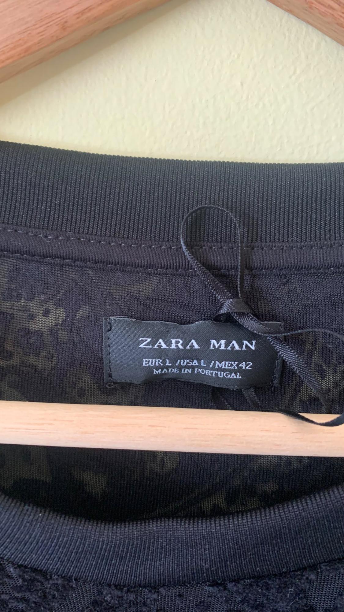 Detail of black label with text 'ZARA MAN EUR L/USA L/MEX 42 MADE IN PORTUGAL'.