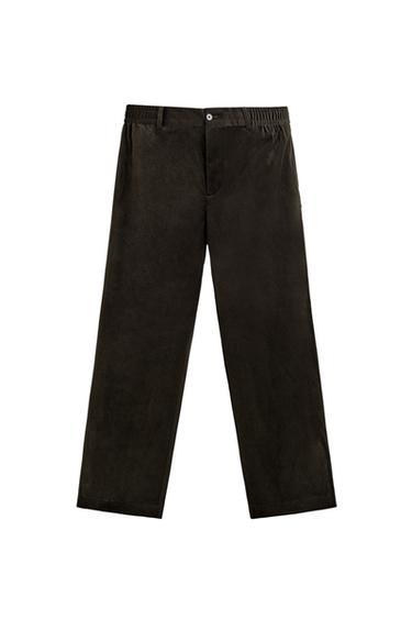 Front view of black trousers with an elasticated waist, welt side and back pockets, and a front zip and button fastening.