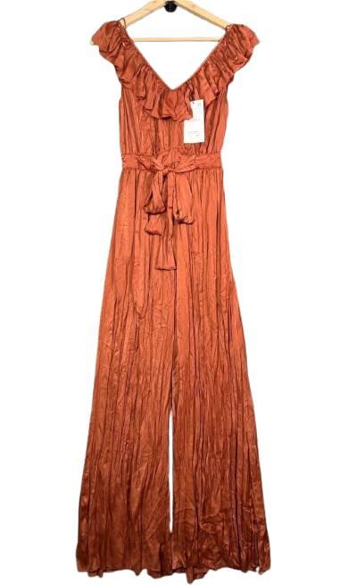Terracotta long jumpsuit with ruffled neckline and matching belt, hanging on a wooden hanger.