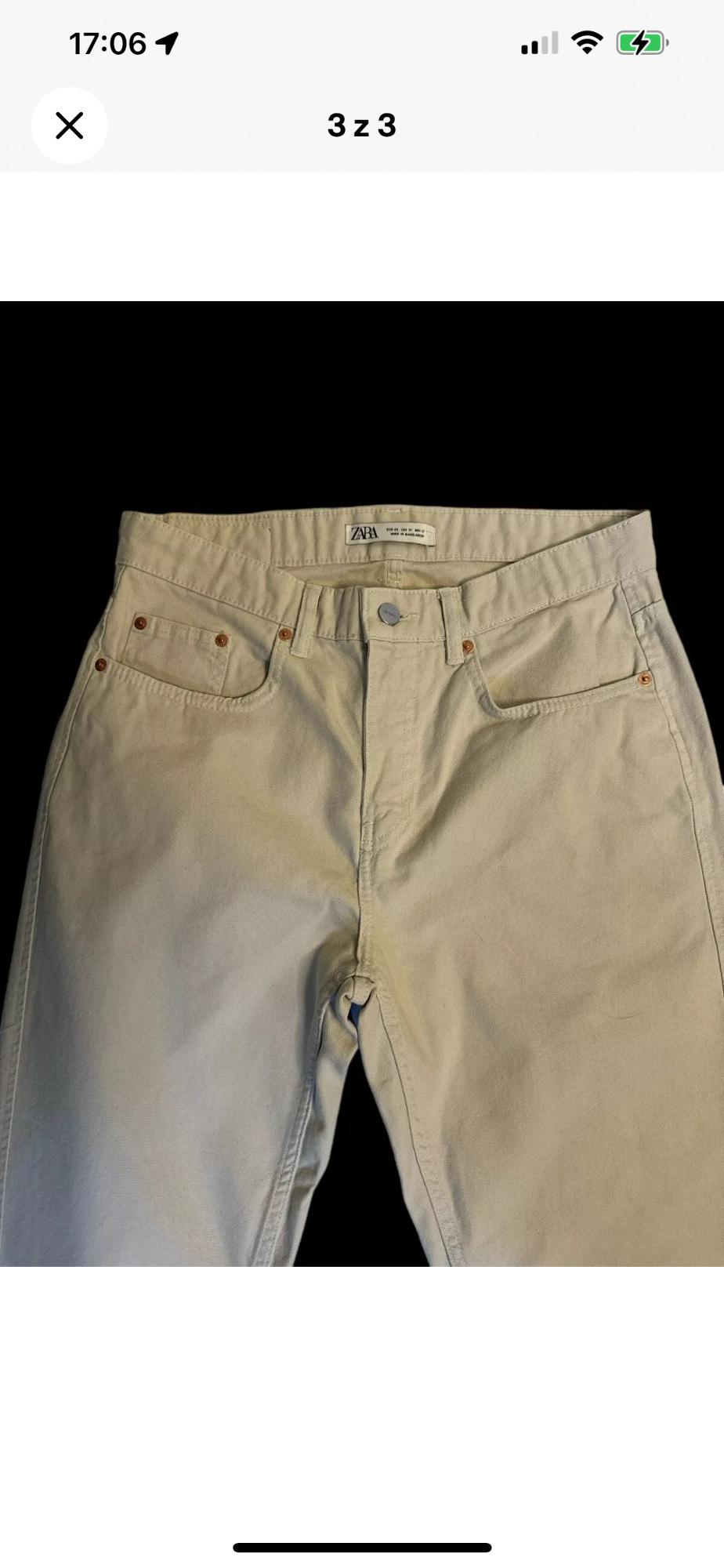 Front view of beige trousers with front pockets and a visible button.