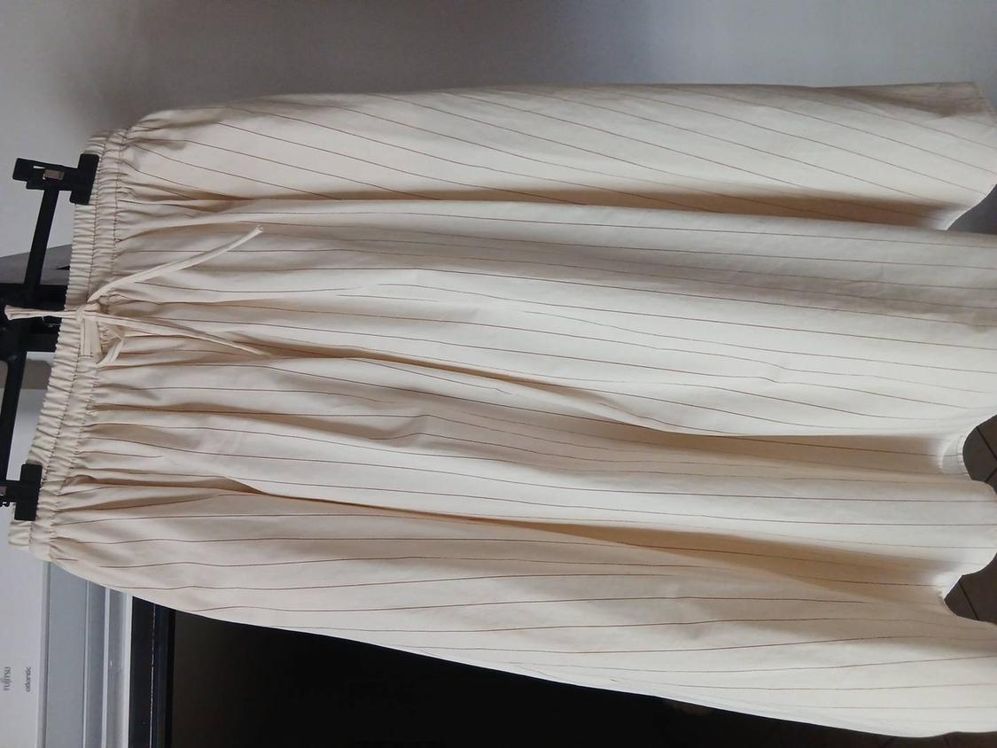 Rotated image. Fine-striped beige garment with elasticated waist and drawstring, hanging on a black hanger. Text: FUJITSU, atlantic.