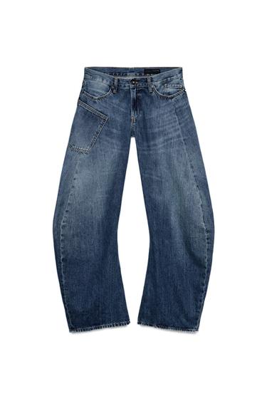 Front view of low-rise blue jeans with curved leg, front and side pockets, washed effect, zip and button fastening.