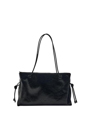 Black shoulder bag with a crinkled texture and glossy finish. Rectangular design with slim handles and side drawstring details on a white background.