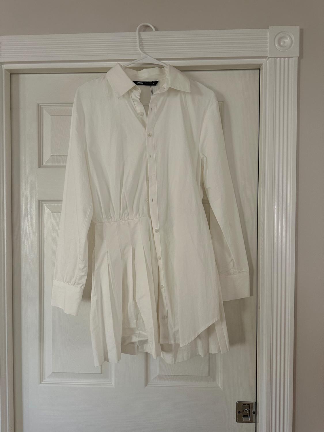 Front view of a white button-down shirt with a classic collar.