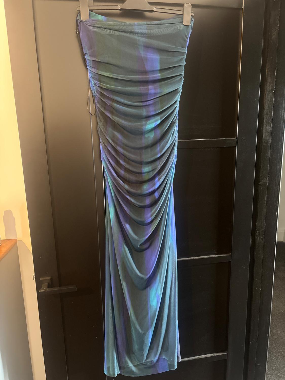 Strapless draped long dress with a blue and purple tone print, hanging on a black door.
