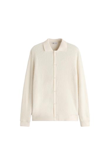 White knitted cardigan with front buttons and a classic collar, displayed on a white background.