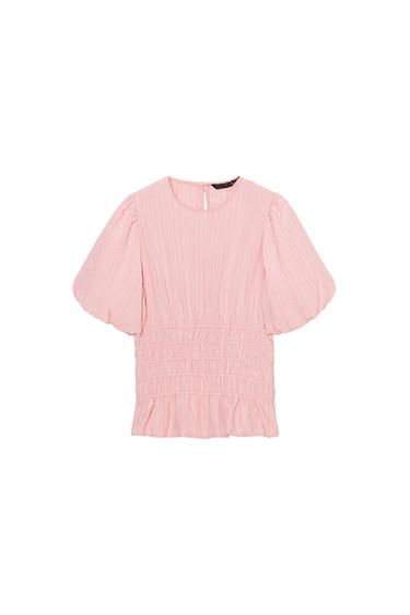 Light pink blouse with puff sleeves and ruched details, white background.