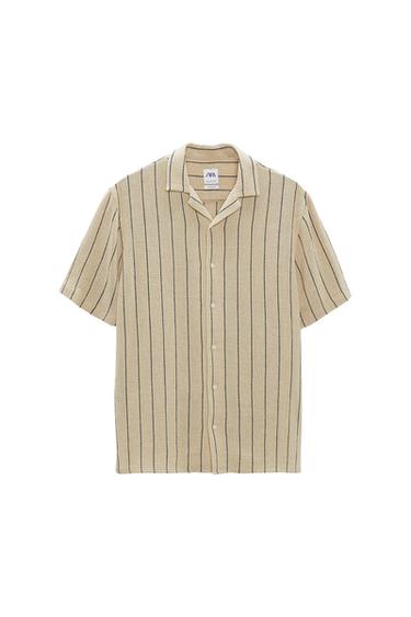 Front view of a beige shirt with black vertical stripes and white buttons.