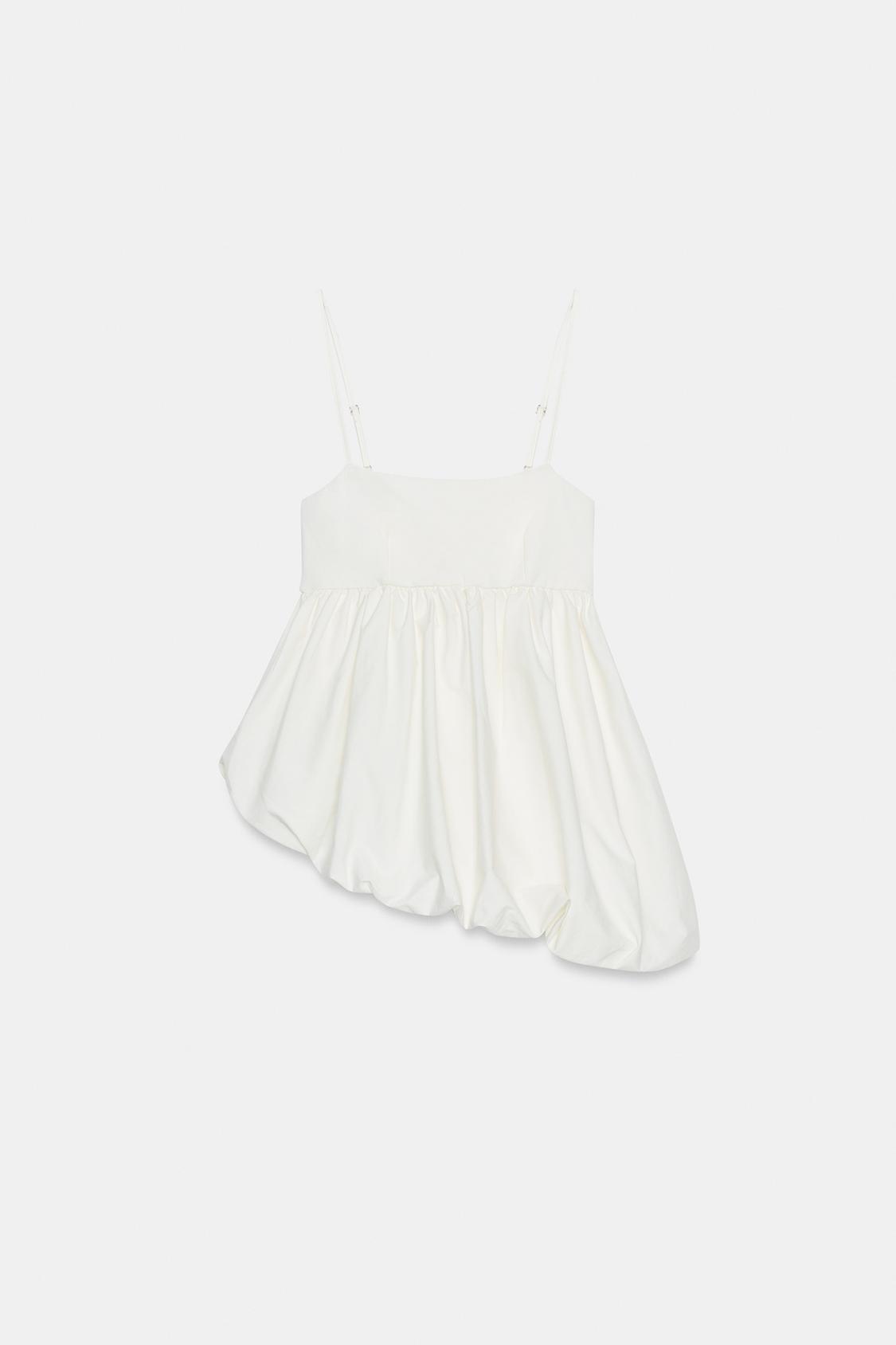 Front view of an camisole with adjustable spaghetti straps, a straight neckline, and a gathered asymmetric hem.
