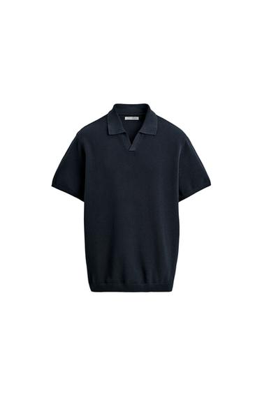 Front view of a navy knit polo shirt with a lapel collar, front opening, and short sleeves. Ribbed trim.