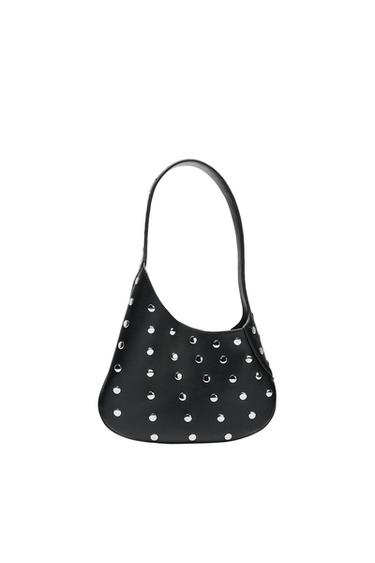Black shoulder bag with an asymmetrical shape and round silver studs, photographed against a white background.