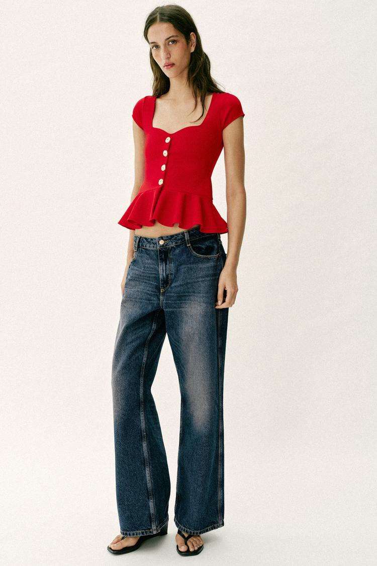 Komplet: P�il�hav� �erven� top s knofl�ky a vol�nkem, tmav� modr� �irok� d��ny s bo�n�mi kapsami a �ern� sand�ly.