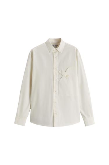 Front view of a white shirt with a classic collar and a buttoned flap chest pocket.
