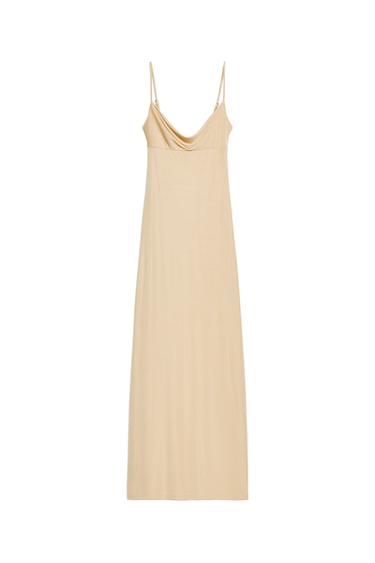 Front view of a light tan maxi dress featuring a cowl neckline and adjustable spaghetti straps.