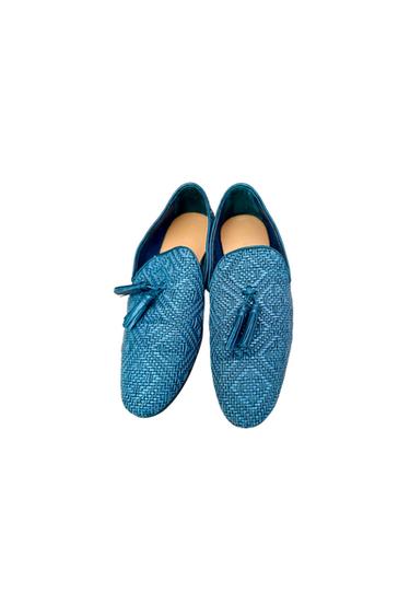 Blue mesh shoes with tassels, viewed from above on a white background. Elegant and modern design.