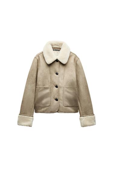 Front view of a beige jacket with front pockets, black buttons and a white faux fur collar.