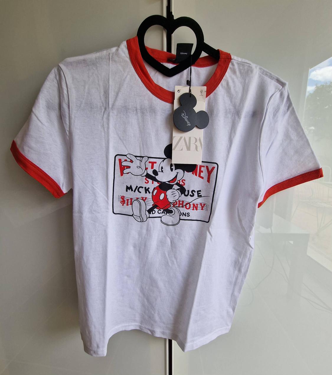 White t-shirt with red trim. Mickey Mouse print, text STUDIOS MICKEY MOUSE SILLY SYMPHONY SOUND CARTOONS. ZARA label.