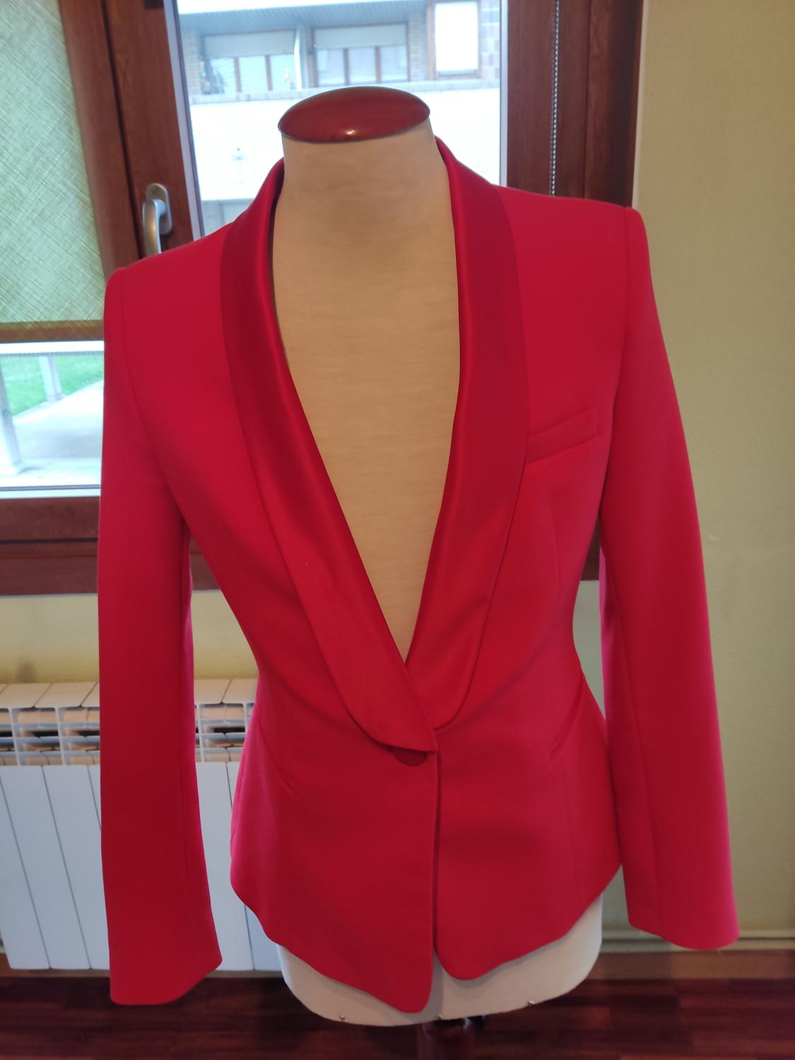 Front view of a red jacket with a long lapel and a breast pocket.