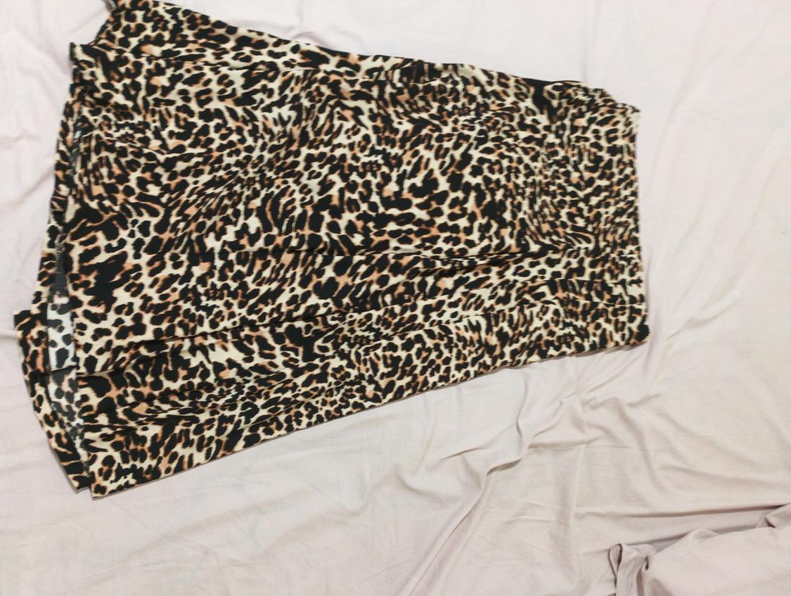 Leopard print skirt on crinkled white fabric. The design features brown, black, and beige tones.