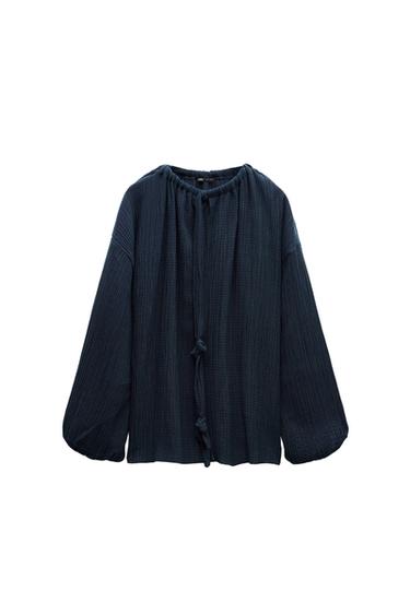 Front view of a navy blue blouse with long sleeves and a tie detail at the neckline.
