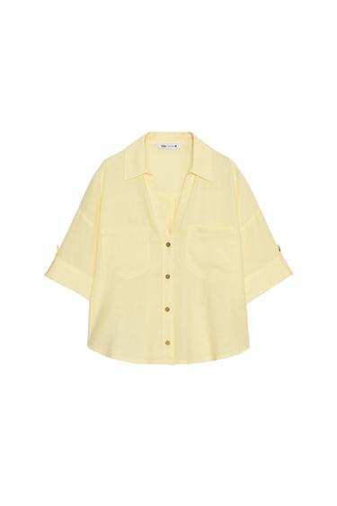 Front view of a yellow shirt with brown buttons and front pockets.