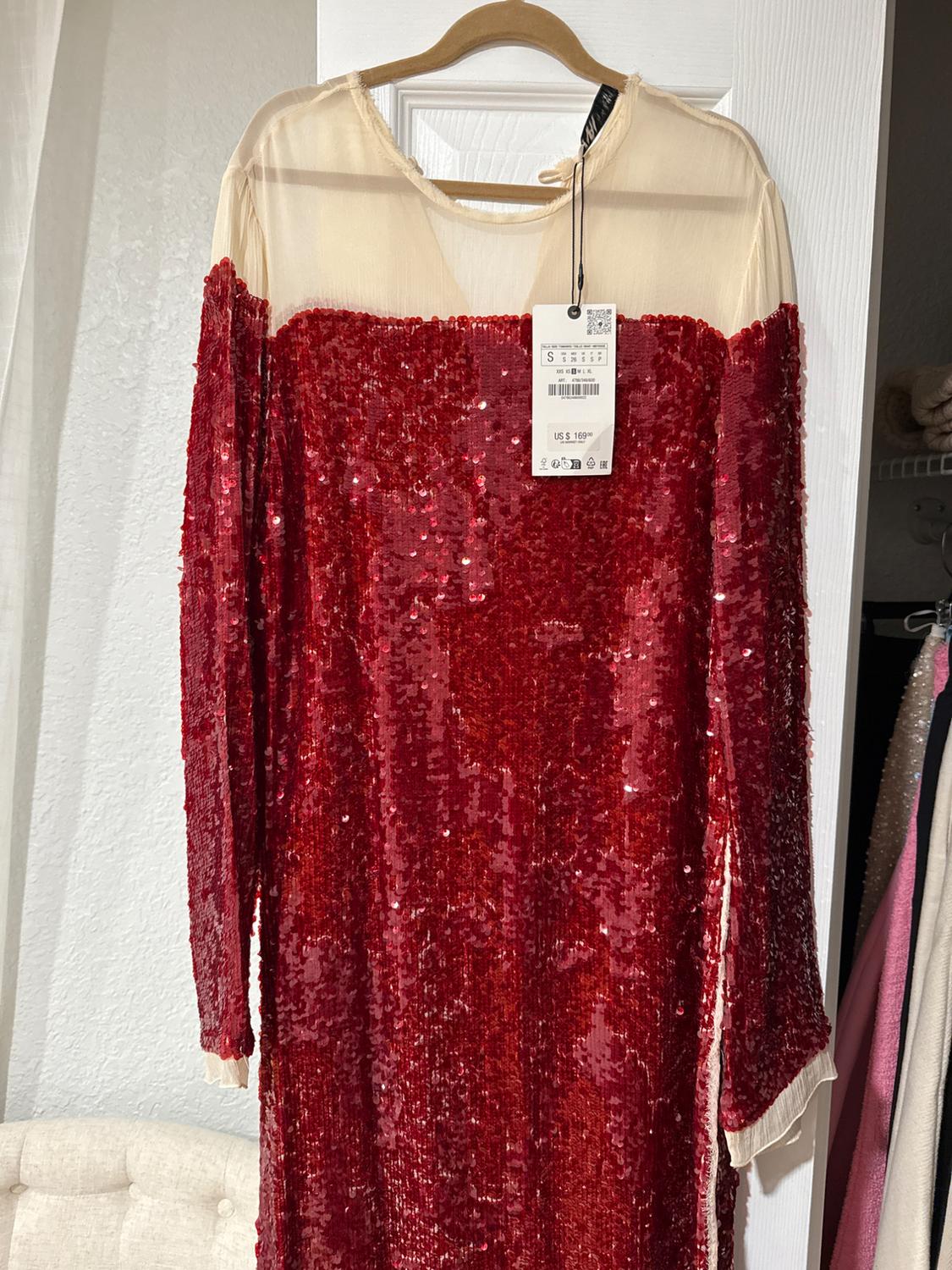 Red sequined dress with a beige mesh top, hanging on a wooden hanger. Visible tag with a price of $109.99.