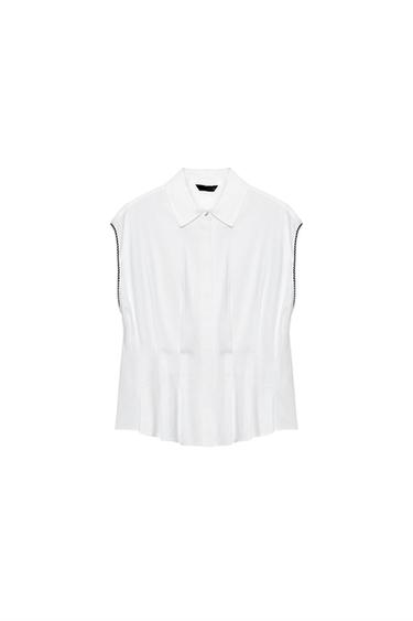 Front view of a white sleeveless shirt with a shirt collar, waist darts, and a concealed button fastening.