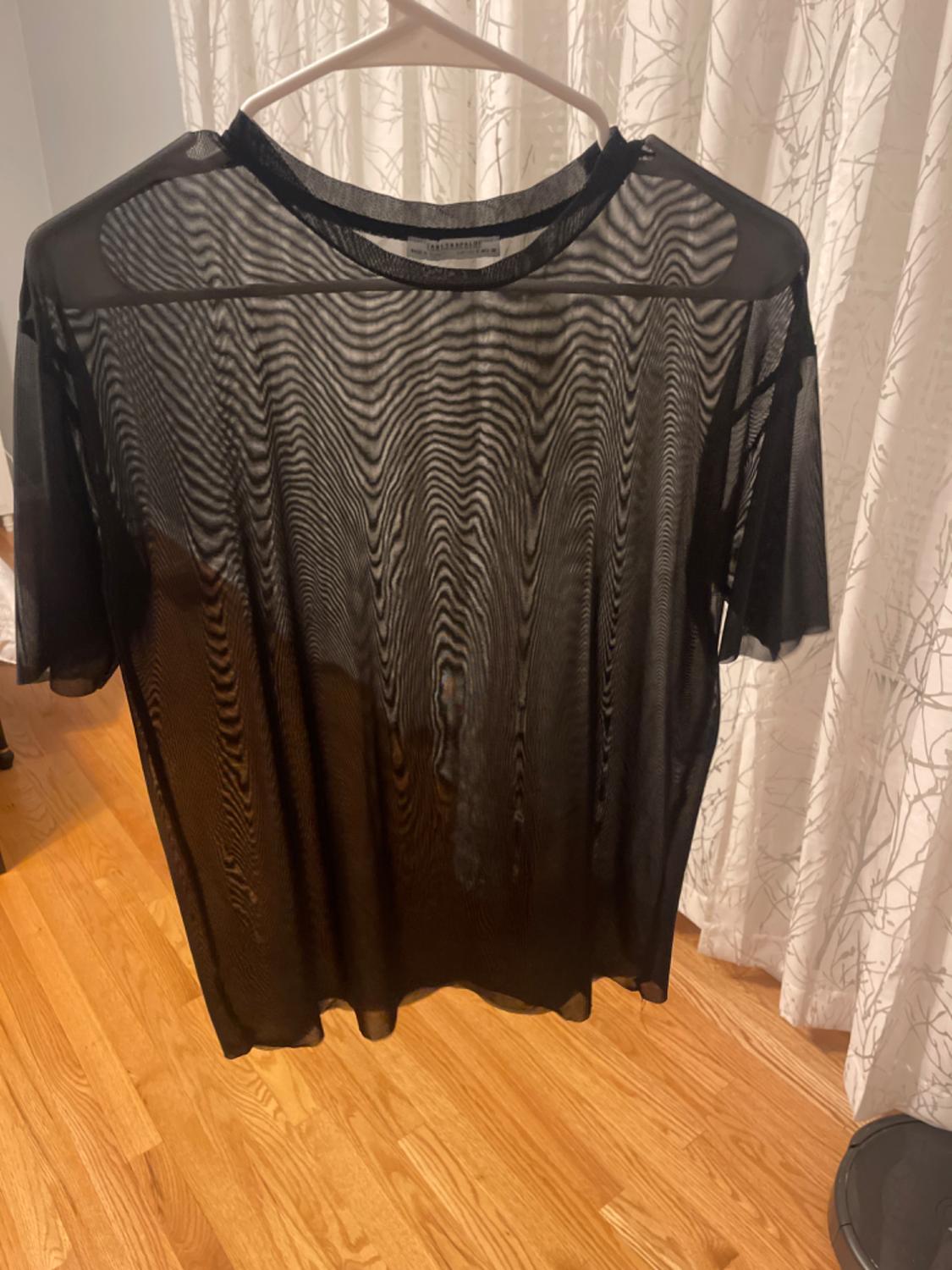 Front view of a sheer black t-shirt with a round neck and short sleeves.