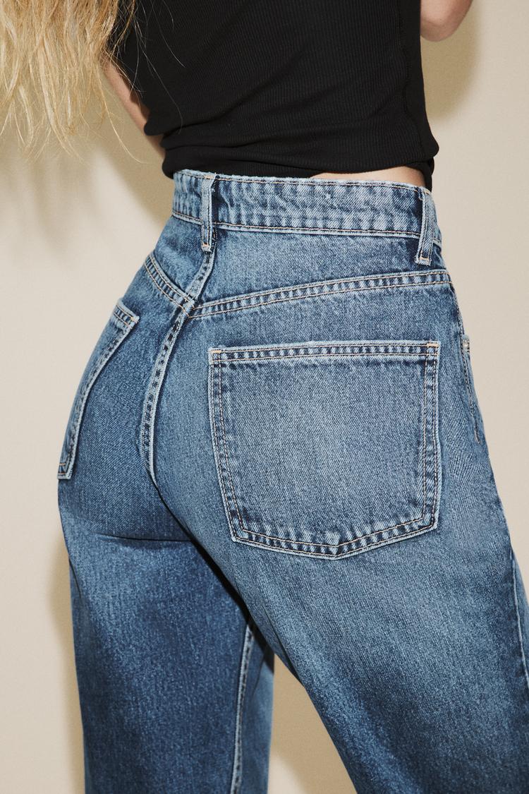 "Srednji posnetek zadnjega dela modrih kavbojk z vidnimi zadnjimi žepi in kontrastnimi šivi."