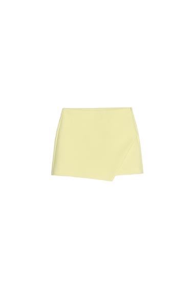 Front view of a short yellow skirt with an asymmetrical hem.