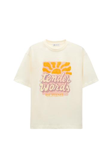 White T-shirt with sun print and text "tender words" in pink and "old signage" in yellow. White background.