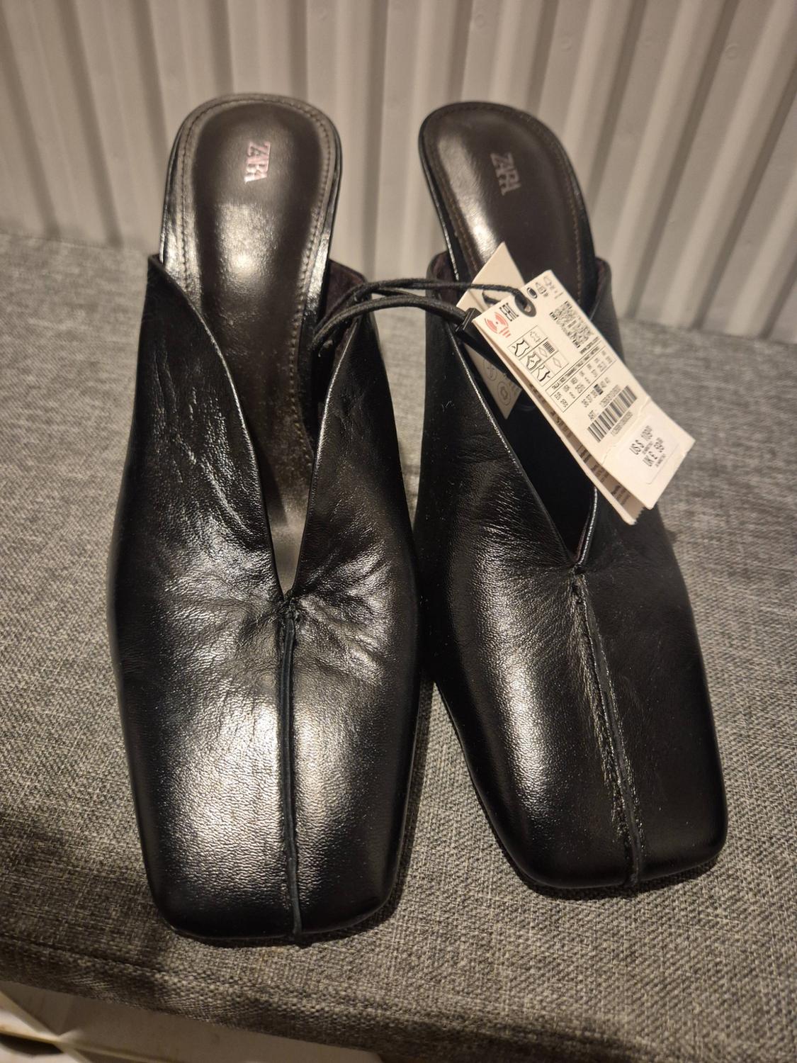 Square-toe black slingback shoes with a V-cut vamp and central seam. zara branding on the insoles.