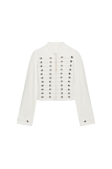 Front view of a white jacket with metal buttons in horizontal rows and a high collar. Long sleeves with buttons on the cuffs.